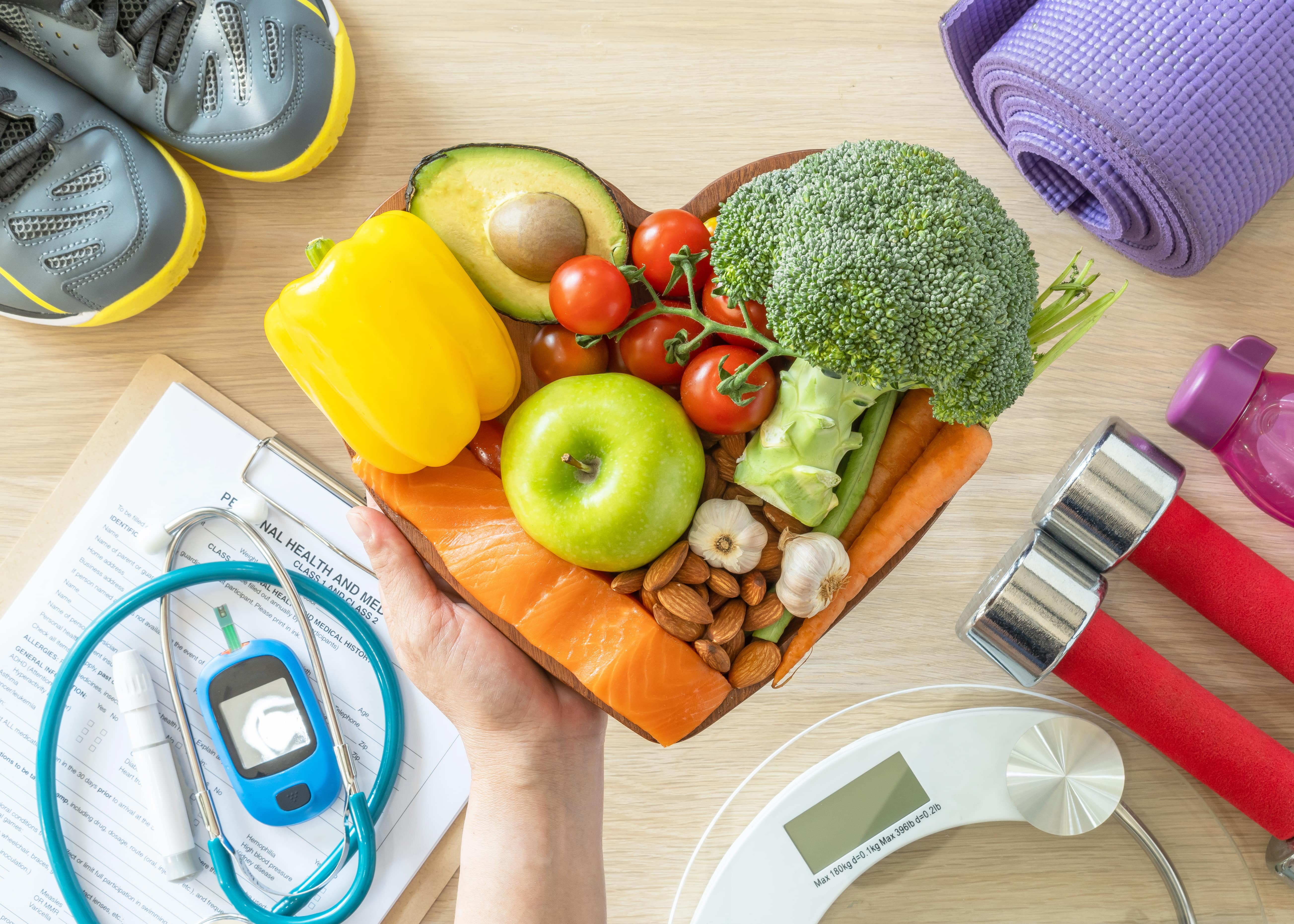 fruits et légumes dans un bol à côté de l'équipement d'exercice